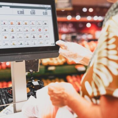 Klient korzysta z oprogramowania sprzedażowego na ekranie dotykowym w sklepie.