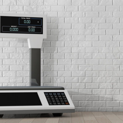 Wagi elektroniczne na tle białej ściany z cegieł.
